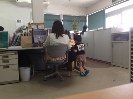 会社で少年（幼児）がヤクルトを飲んでいる風景。